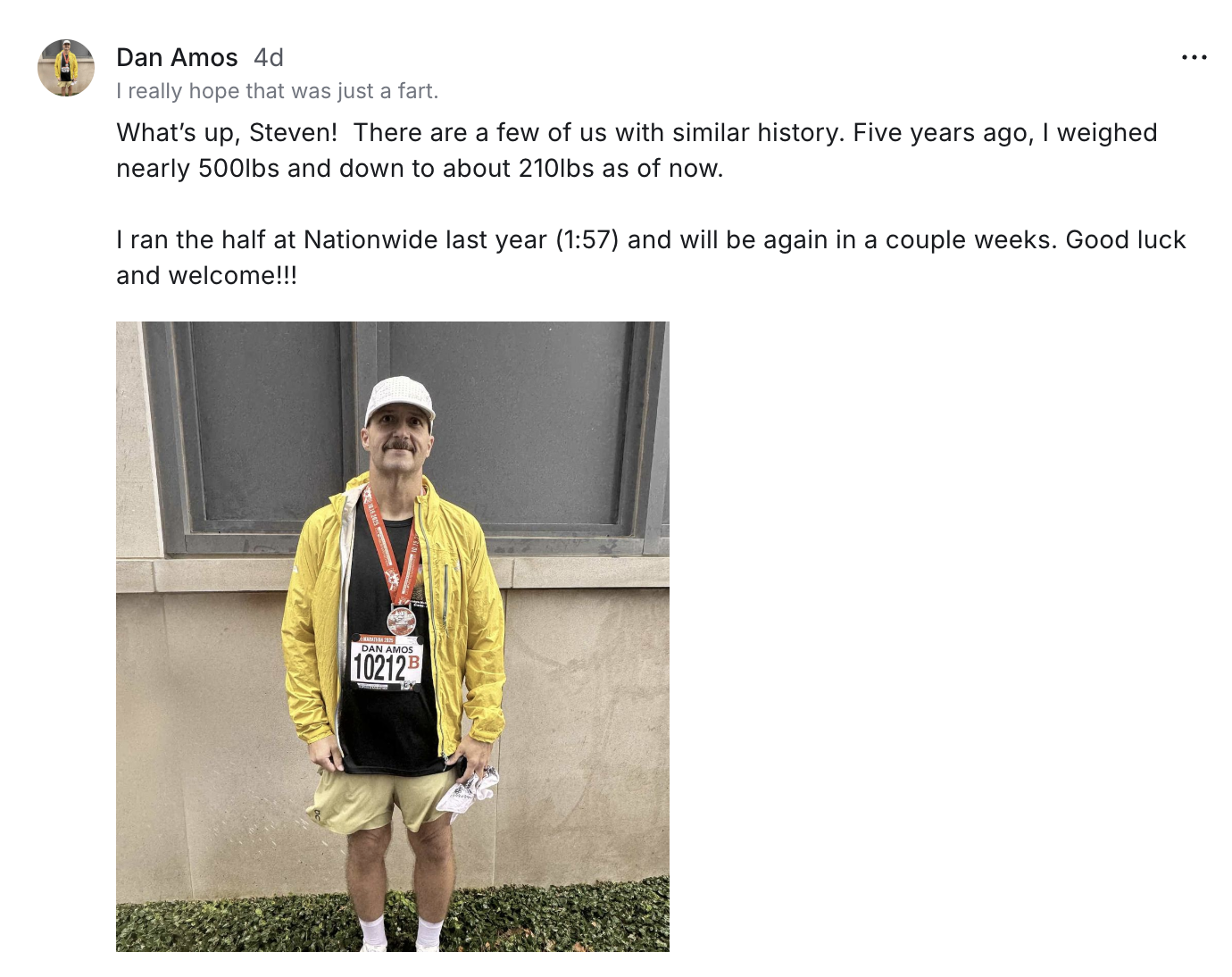 Community post from member Dan Amos sharing a race-day photo wearing a yellow jacket and a race bib.